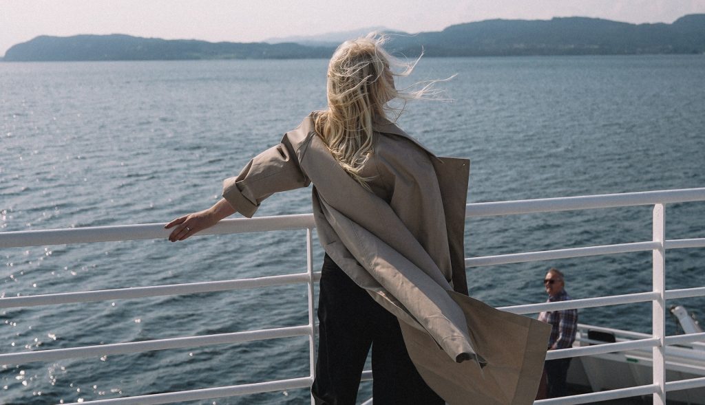Woman Standing By The Side Of A Watercraft. Photo Cred: alleksana