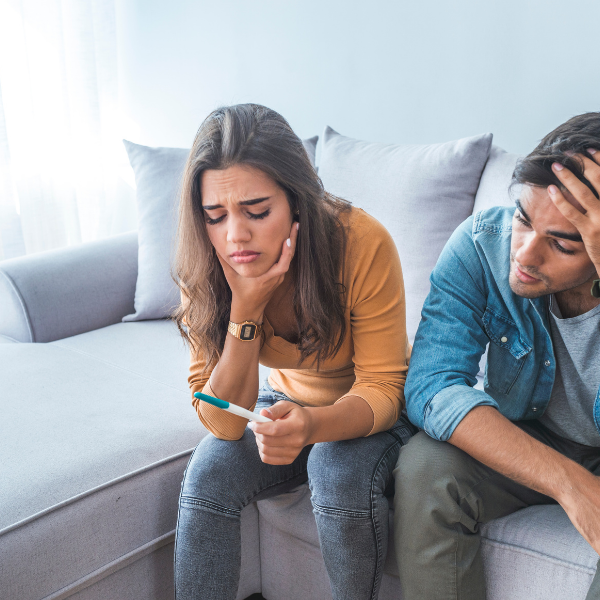 Couple looking sad with negative pregnancy test