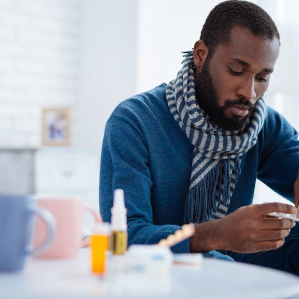 Serious calm man taking a pill from a pill box
